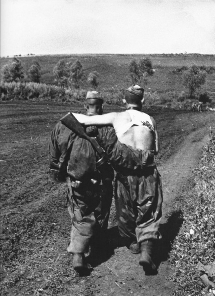 Советский боец помогает идти своему раненому в бою товарищу...0