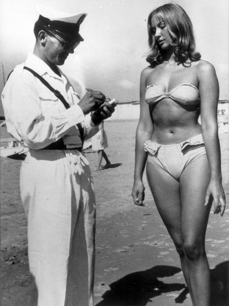 Полицейский выписывает штраф женщине за ношение бикини на пляже..0