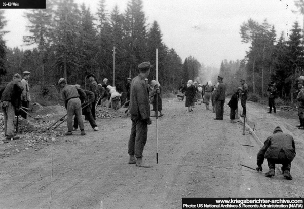 Немцы совместно с местным населением асфальтируют дорогу...0