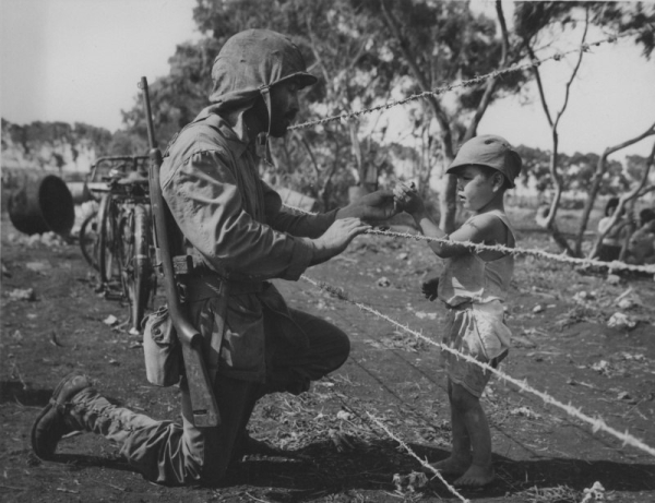 Американский морской пехотинец угощает конфетой японского..0