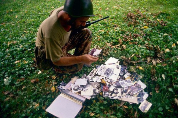 Грузинский солдат рассматривает фотоальбом разбросанный на..0