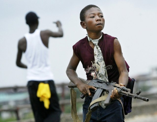 Либерийский ополченец, лояльный правительству, уходит от..0