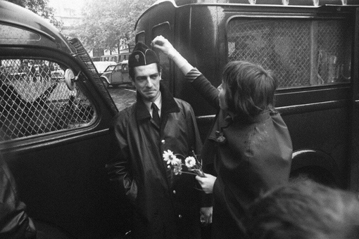 Девушка украшает полицейского цветочком во время студенческих..0