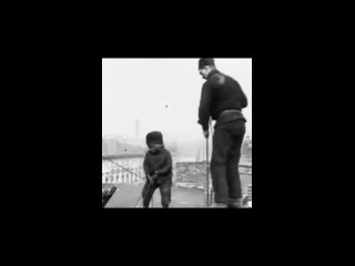 Мальчику 3 года, и он помогает отцу чистить дымоход на крыше...0
