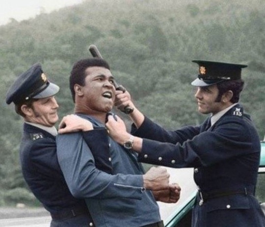 Мохаммед Али позирует в постановочном фото с двумя местными ..0