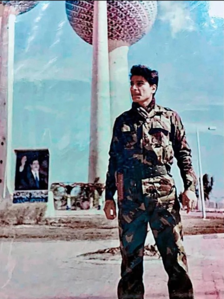 Иракский солдат на фоне портрета Саддама Хусейна. Кувейт, 1990..0