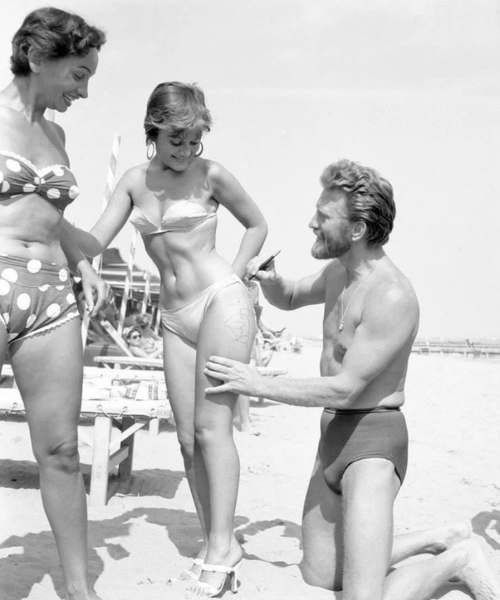 Кирк Дуглас оставляет автограф на бедре девушки. Италия, 1953..0