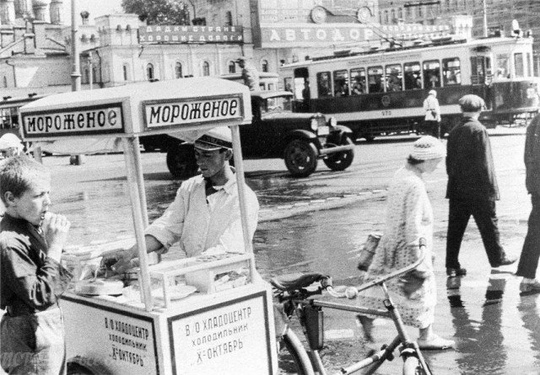 Уличная продажа мороженого. На заднем плане лозунг «Дадим стране..0