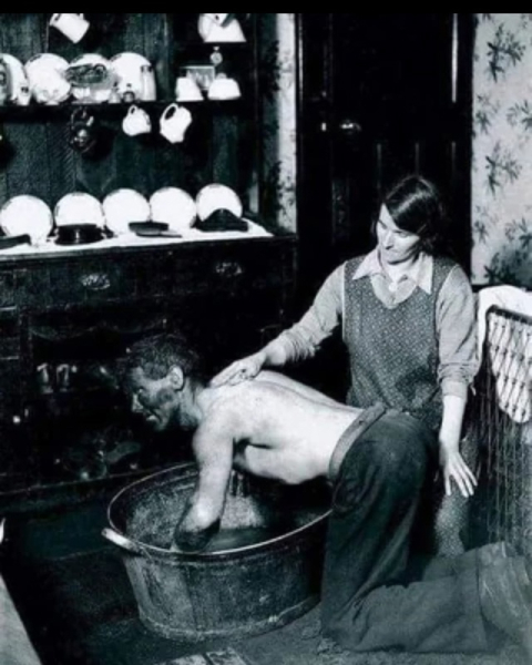 Жена моет своего мужа-шахтëра после смены. Уэльс, 1931..0