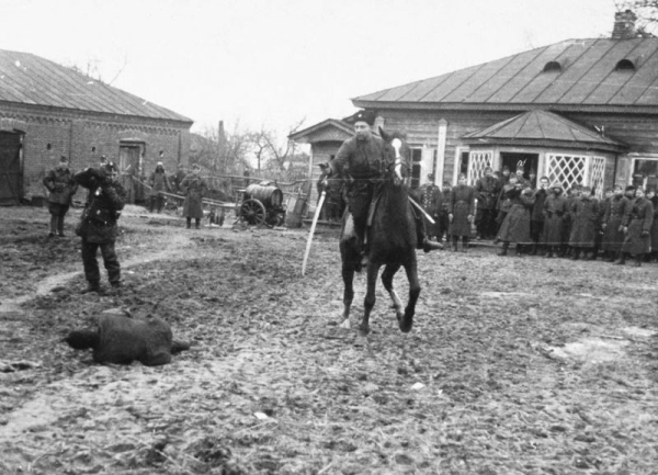 Донской казак-полицай рубит шашкой пленных советских партизан..3