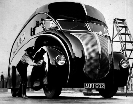 Водитeль полирует автомобиль в стиле ар-деко, Англия, 1933..0